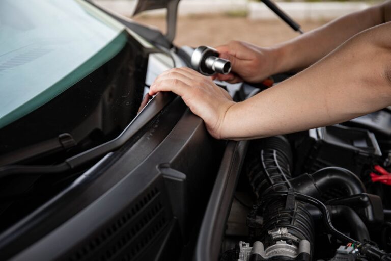 Person holding a socket wrench while replacing car wipers