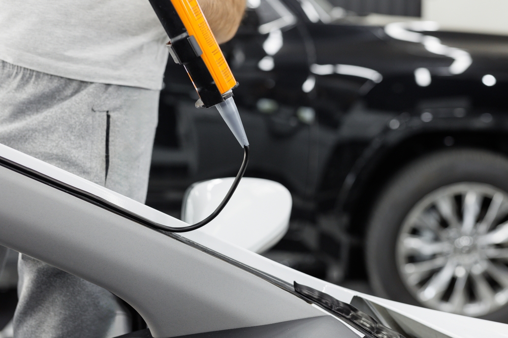 Technician replacing a damaged windscreen seal on a vehicle in Sydney