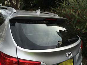 Red hatchback window from the outside showing broken glass