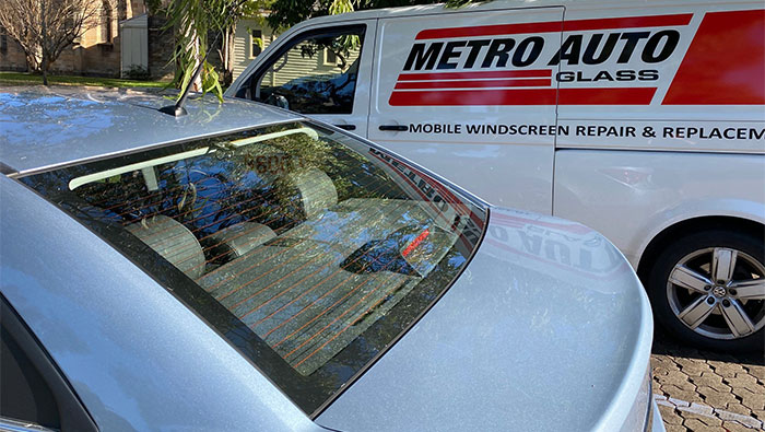 New rear window in vehicle with Metro Auto Glass service van in the background